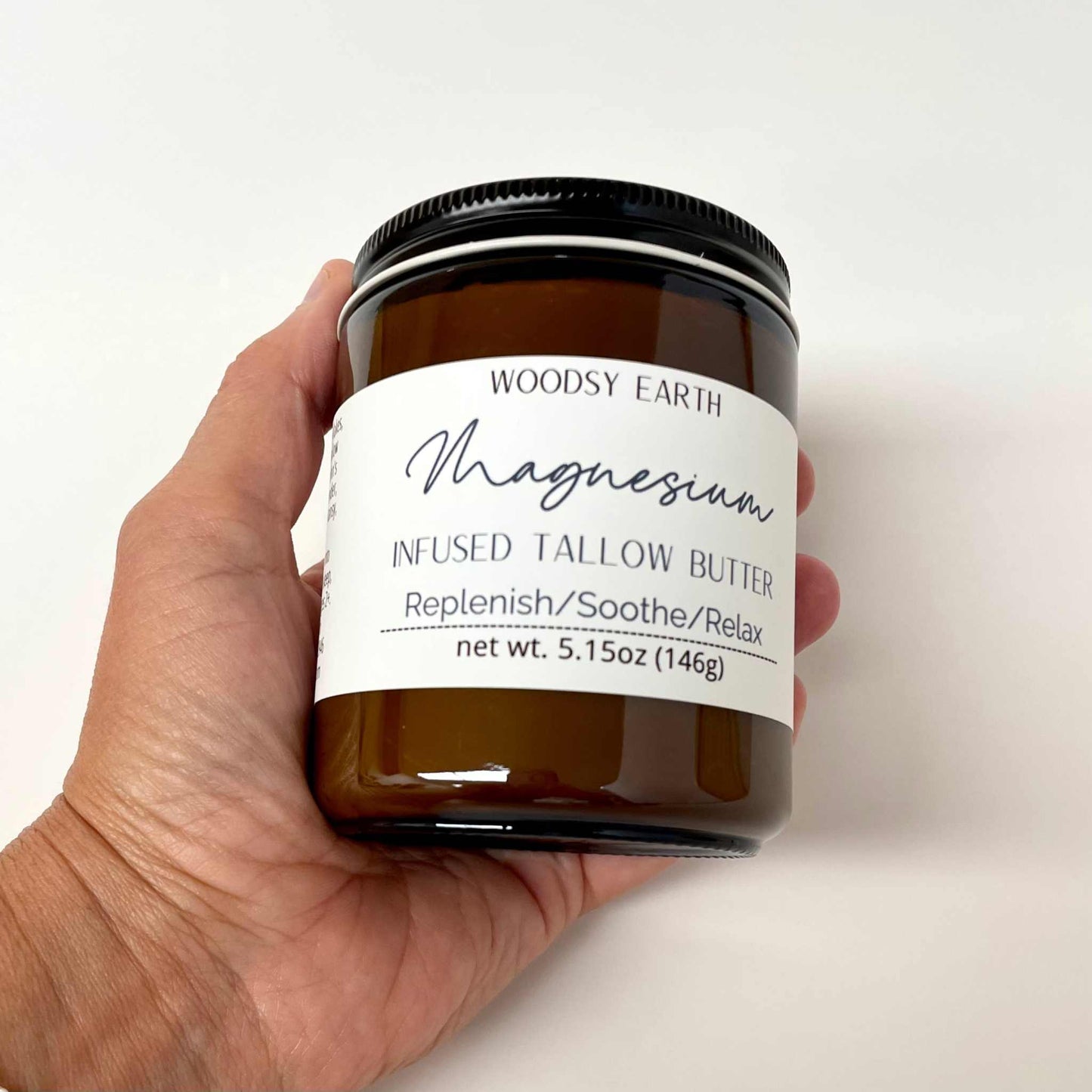 Amber jar of Magnesium Butter cream with herbal ingredients on wooden surface