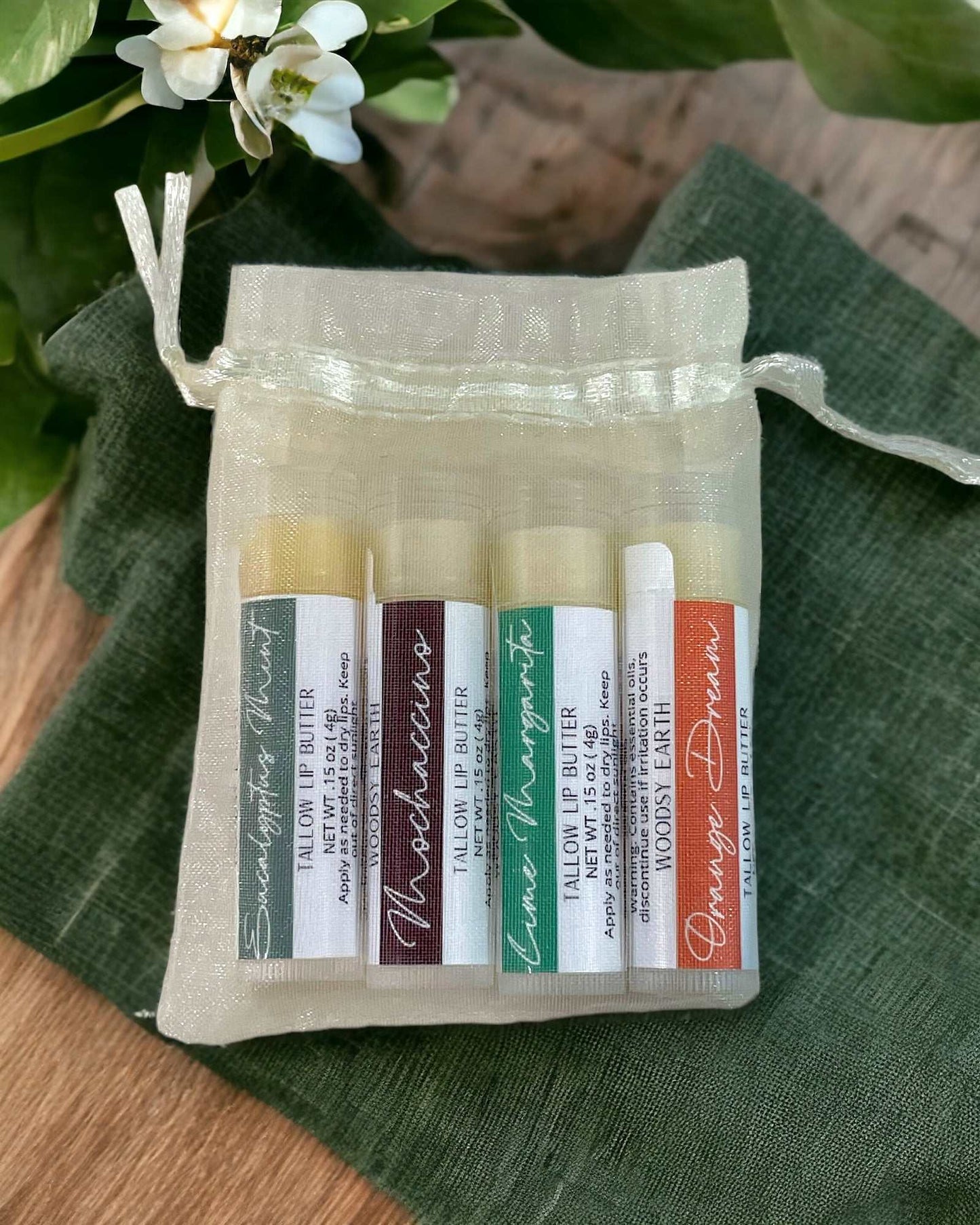 Woodsy Earth tallow lip butter variety pack in an organza bag with five natural flavors, including nourishing blends made with grass-fed tallow and beeswax.
