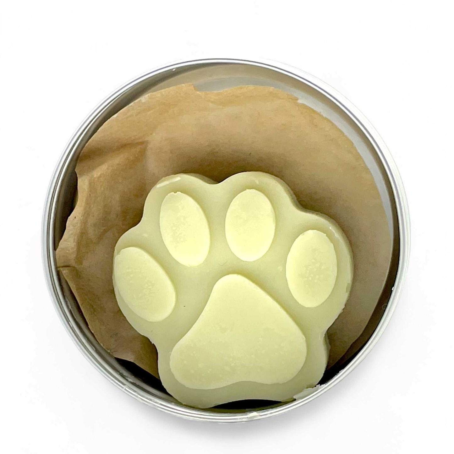 Natural paw balm lotion bar in paw print shape, packaged in a reusable tin, soothing for dry or cracked pet paws.