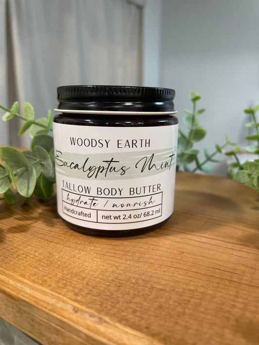 Eucalyptus Mint Body Butter in jar with eucalyptus leaves, nourishing and soothing skincare product.