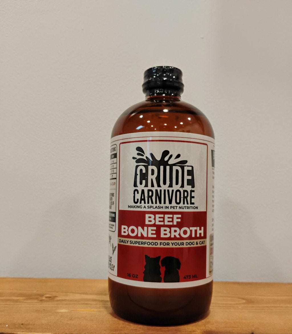 Crude Carnivore Beef Bone Broth bottle on wooden surface.