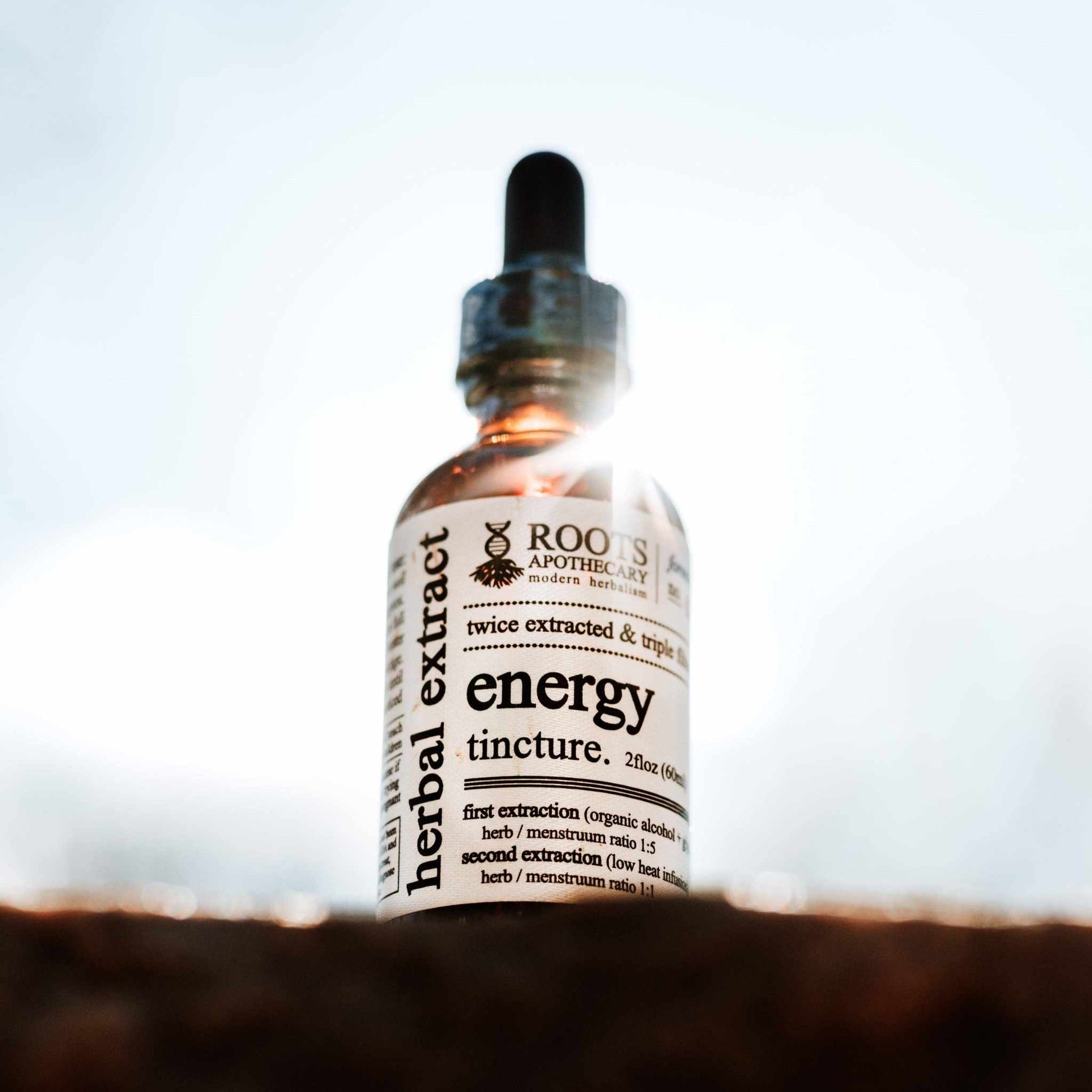 Roots Apothecary Energy tincture bottle with herbal extract ingredients, featuring a natural energy boost blend.