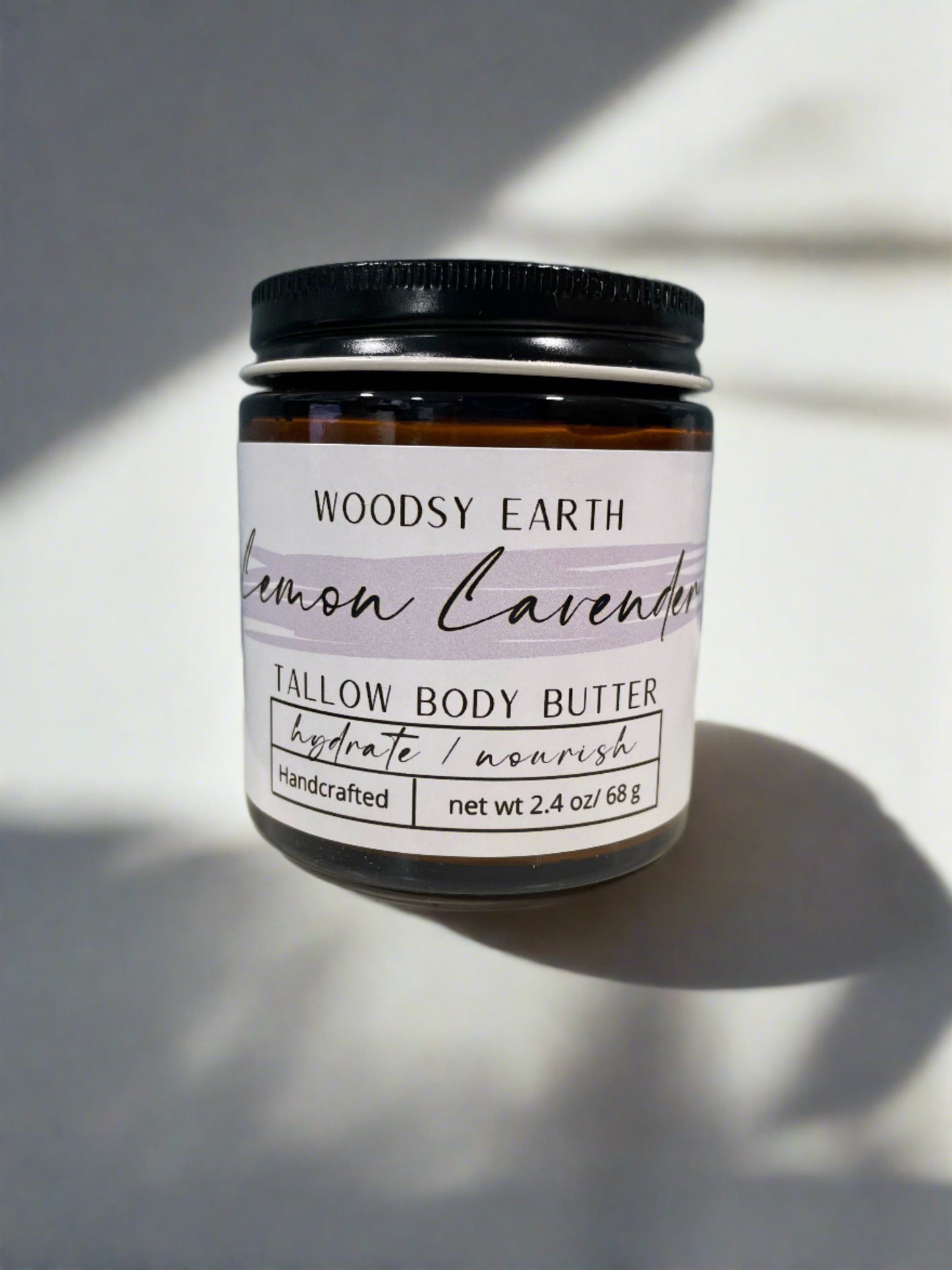 Woodsy Earth Lemon Lavender Whipped Body Butter jar displayed on a natural background, showcasing its creamy texture and soothing scent