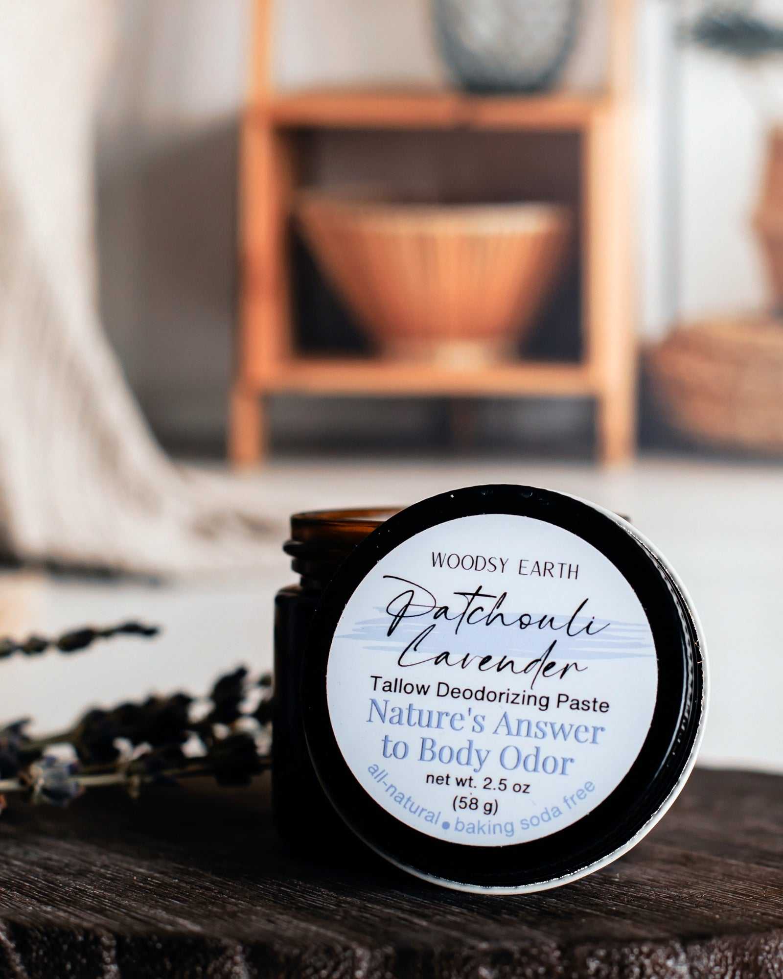 Natural deodorizing paste in a dark jar, labeled "Patchouli Lavender," made with essential oils and no synthetics.