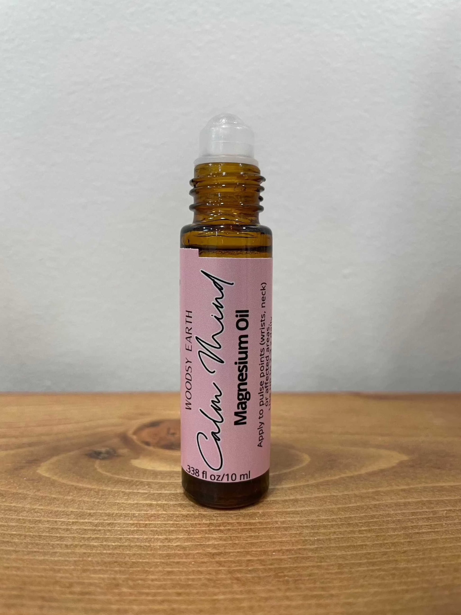 Magnesium Oil Roll-On for Calm Mind on wooden surface.