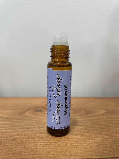 Magnesium oil roll-on bottle for deep sleep on wooden surface.