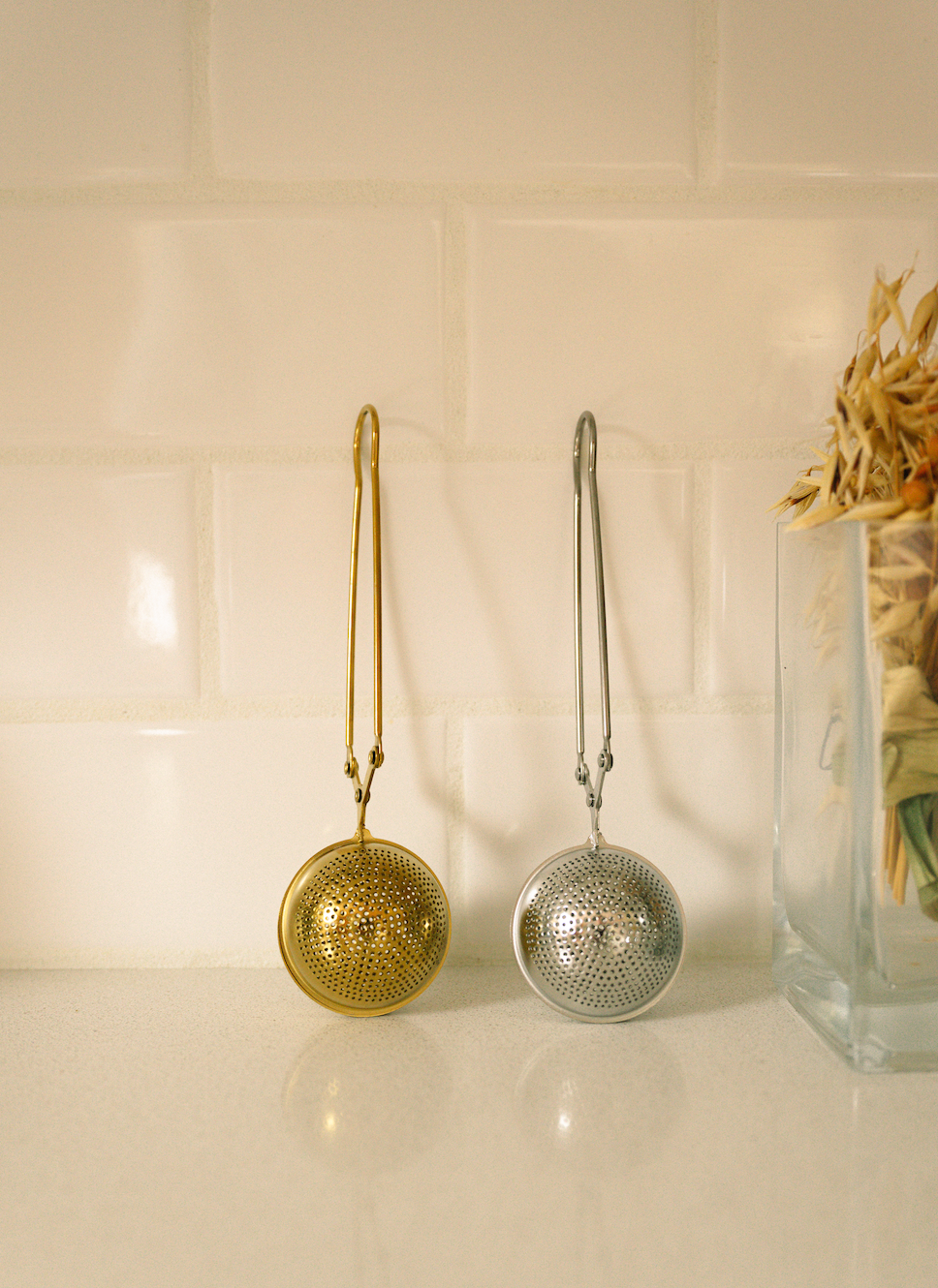 Bamboo Switch stainless steel tea strainers in gold and silver, eco-friendly loose leaf tea infusers on a countertop.