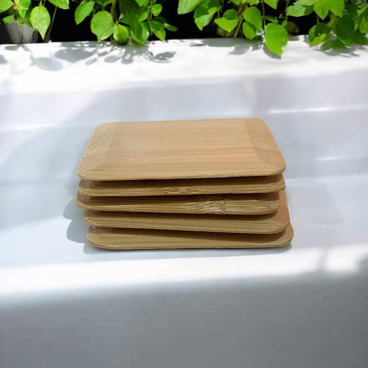 Stack of eco-friendly Bamboo Switch pot scrapers displayed on a white surface, sustainable kitchen cleaning tools.