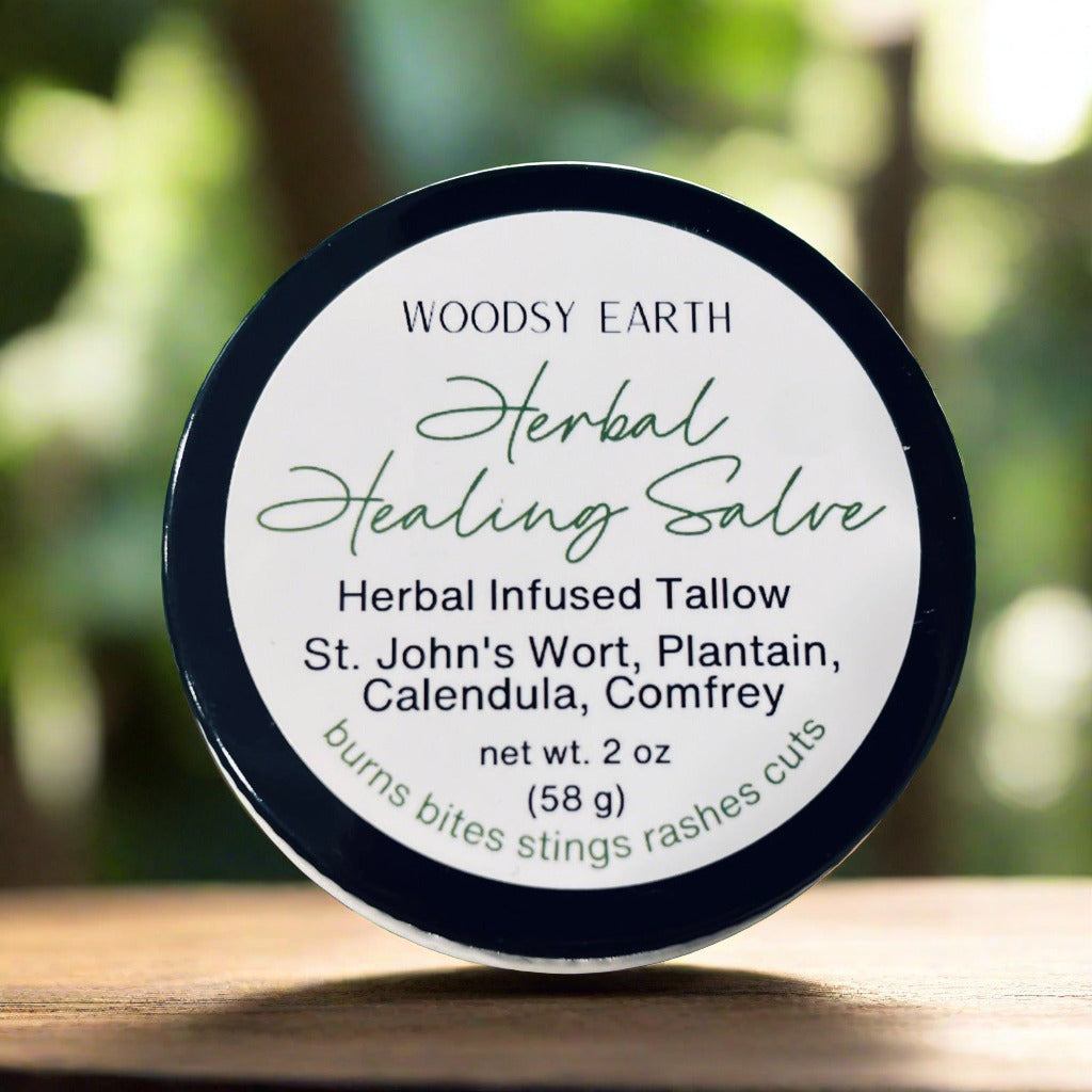 Woodsy Earth Herbal Healing Salve in amber glass jar with labeled lid showing herbal infused tallow ingredients including St. John’s Wort, plantain, calendula, and comfrey