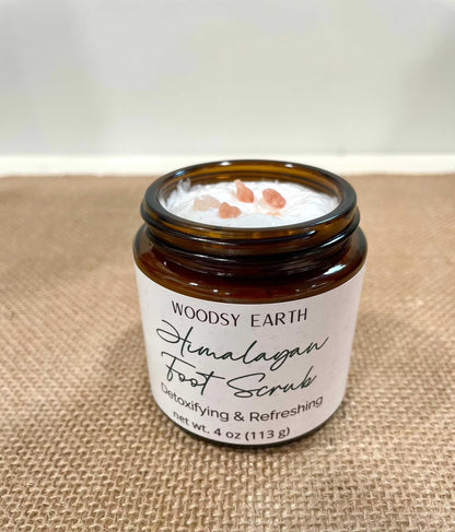 Woodsy Earth Himalayan Foot Scrub in amber glass jar with visible pink Himalayan salt crystals on top, placed on burlap surface