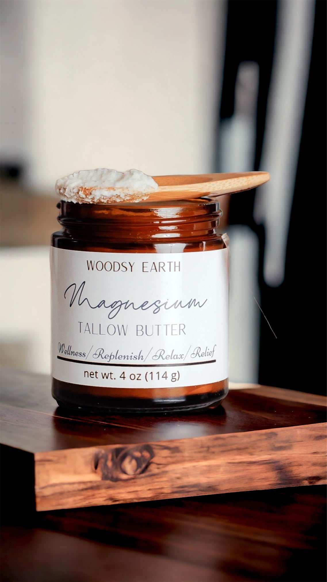 Woodsy Earth Magnesium Tallow Butter in 4 oz amber jar with wooden scoop, infused with rosemary and St. John’s Wort for relaxation, sore muscles, and natural pain relief.