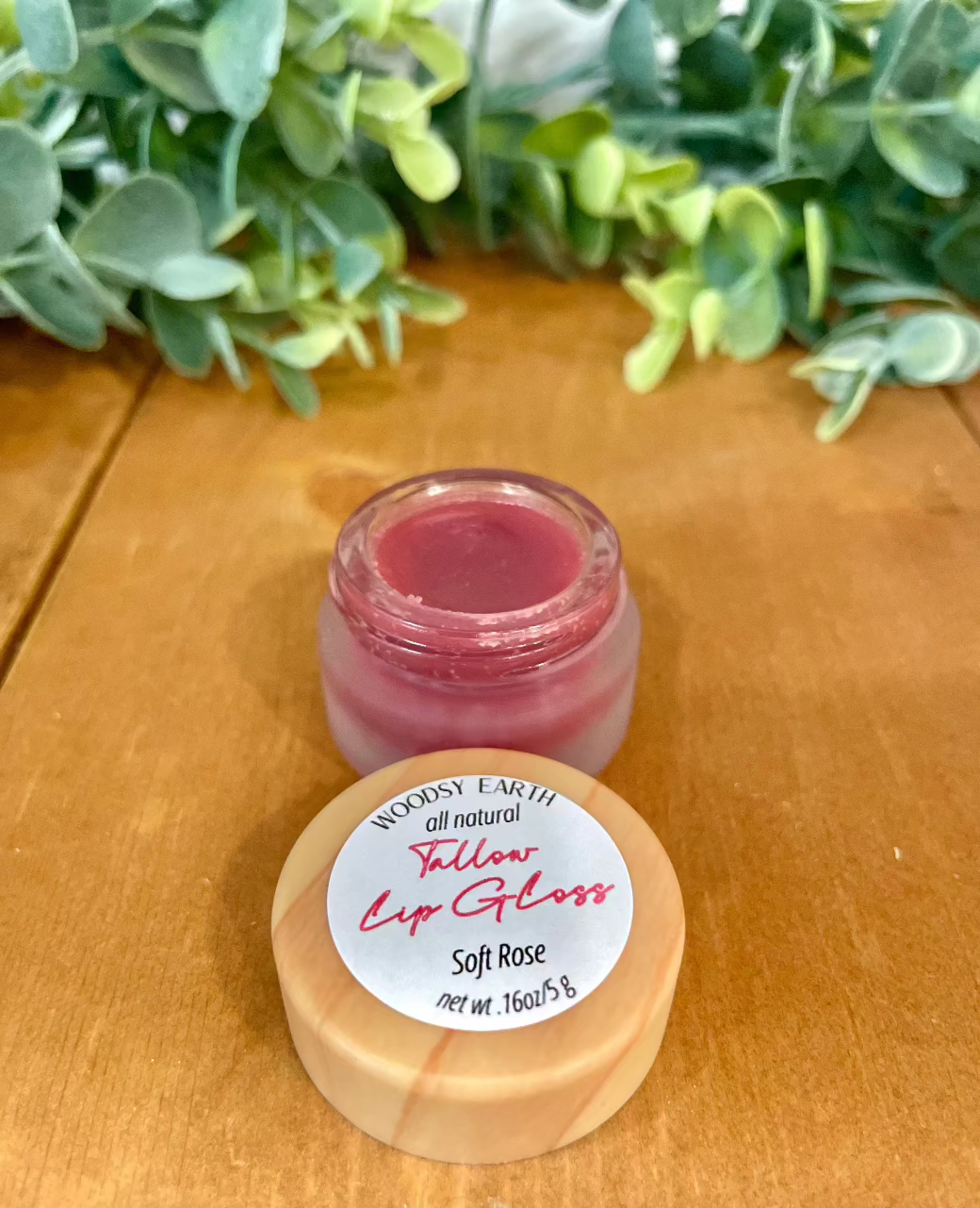 Woodsy Earth Soft Rose Tinted Tallow Lip Gloss in open glass jar with wooden lid, natural moisturizing color.