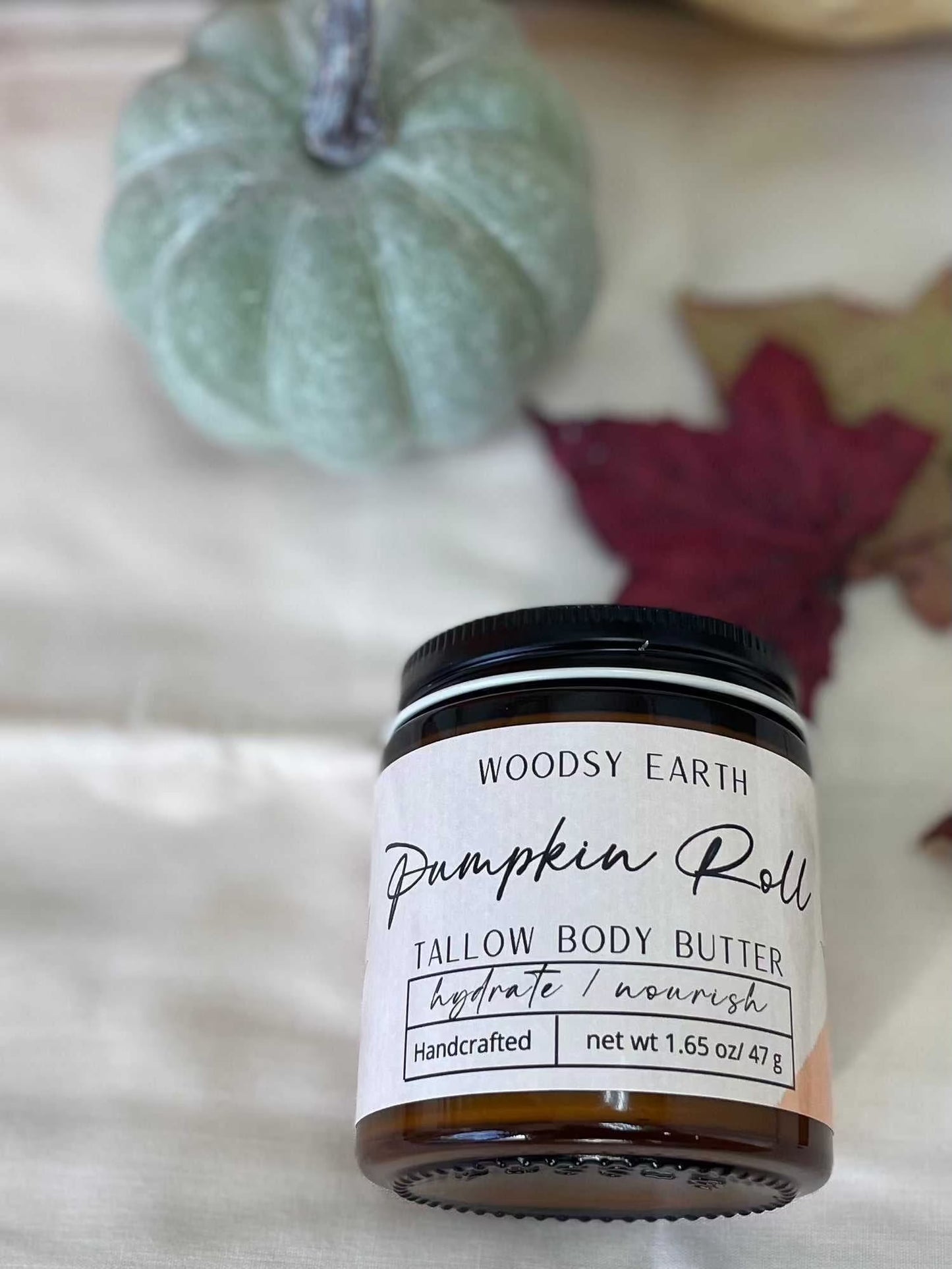 Woodsy Earth Pumpkin Roll Tallow Body Butter in a 1.65 oz jar, handcrafted for hydrating and nourishing skin with cozy fall vibes.