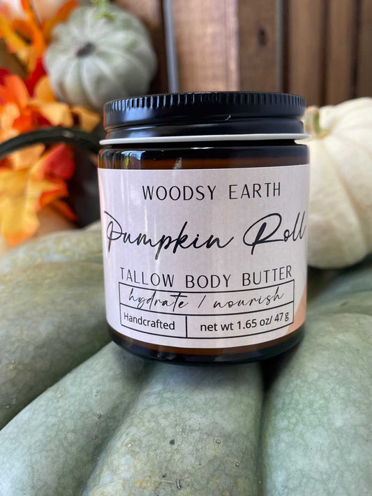 Woodsy Earth Pumpkin Roll Tallow Body Butter in amber jar with pumpkins and fall leaves, hydrating and nourishing handcrafted skincare