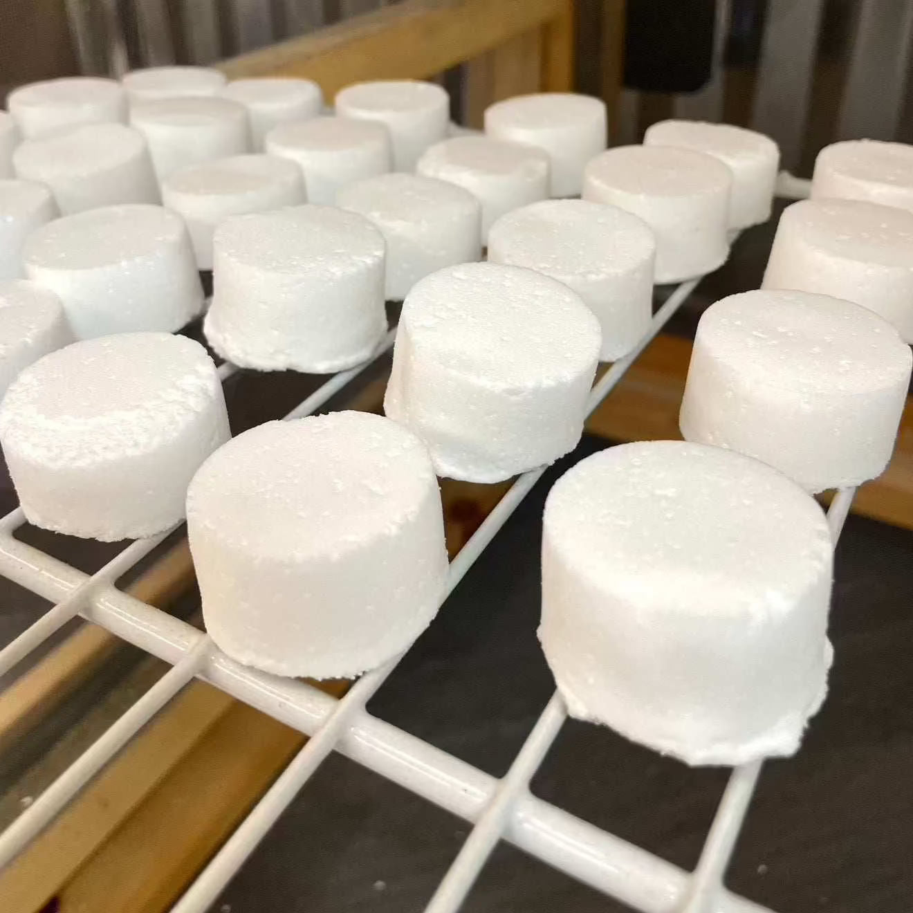 Freshly made natural toilet fizzies drying on a rack, eco-friendly cleaning for bathrooms.