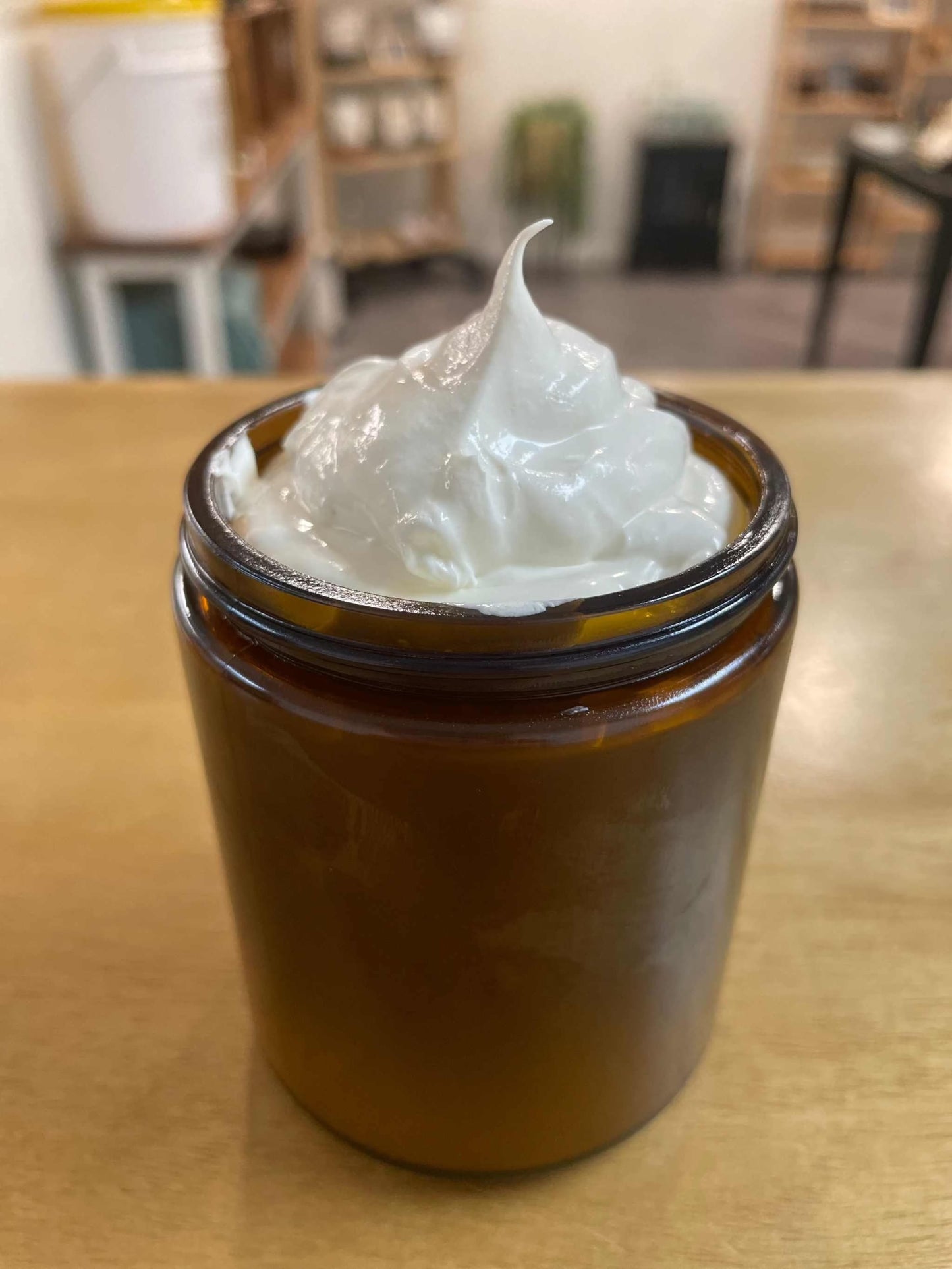 Woodsy Earth whipped vanilla body butter in amber glass jar with creamy, fluffy texture on display
